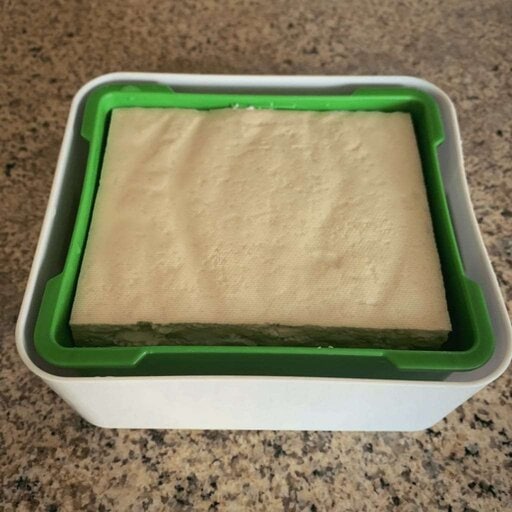 Place the tofu into the strainer, and place the strainer into the outer container
