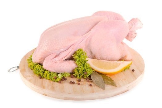 A fresh chicken on chopping board on white bg