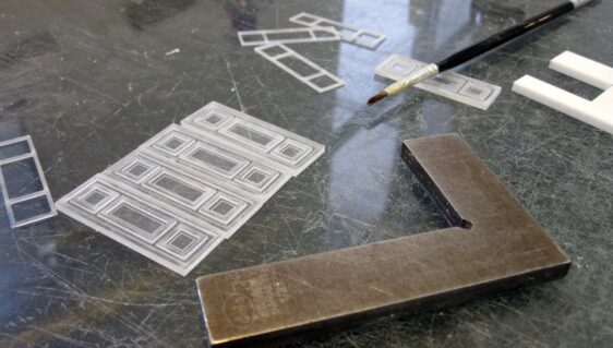 outils de maquettiste sur un bureau pendant le montage d'éléments d'une maquette