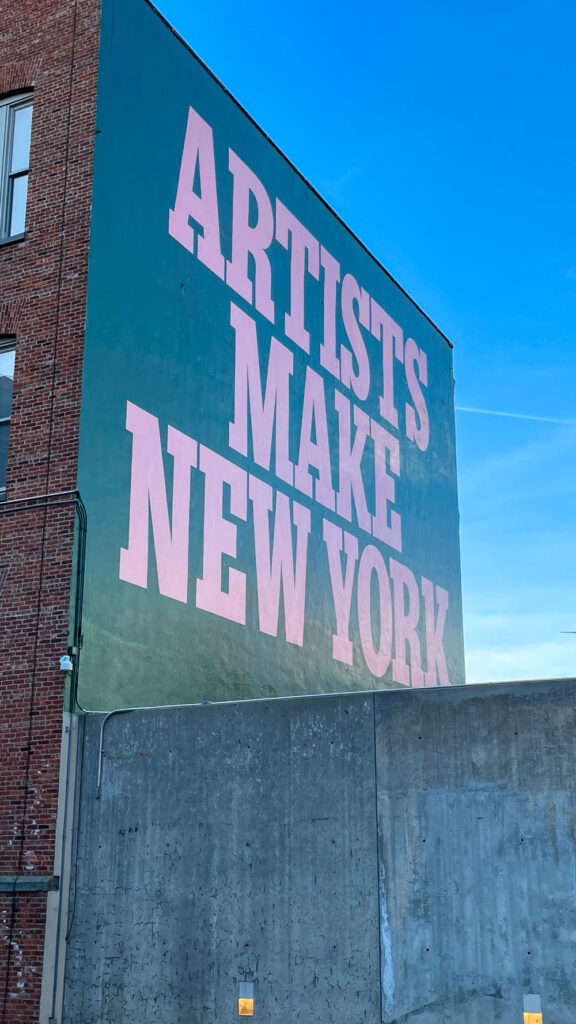 Brick wall of MoMA PS1 Museum in Queens saying Artists Make New York