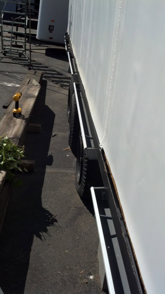 Here are the planters [gutters] right after being installed on the house.  We installed these just like a typical gutter only onto the very bottom of the subfloor.  These do make my house wider than the required 8'-6" which is important to note.  Originally I had been intending to install these where they would be removable but instead I opted for this for a couple reasons...  First, if the ivy grows up the side and is rooted in these it isn't really very 'removable' anyway.  Second, it is easier this way.  Third, the tire STILL sticks out further than the gutters and the tire passed inspection before... I thought it was worth risking.  Worst case scenario I need to pay a few bucks and get a permit through the DMV each time I need to move which won't be too bad, I don't plan on moving it a whole lot. 