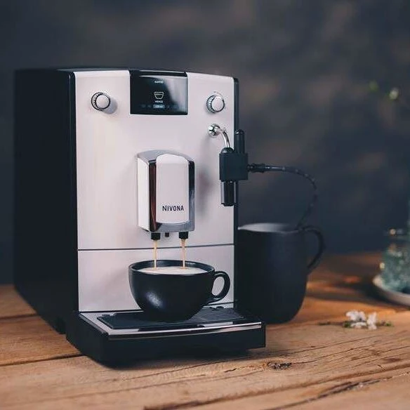 Černobílý kávovar Nivona po servisu připravující kávu
