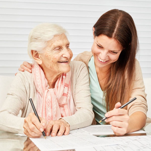 Junge Pflegerin hilft Seniorin