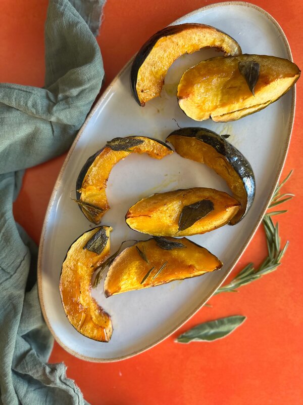 maple roasted acorn squash wedges on serving plate"