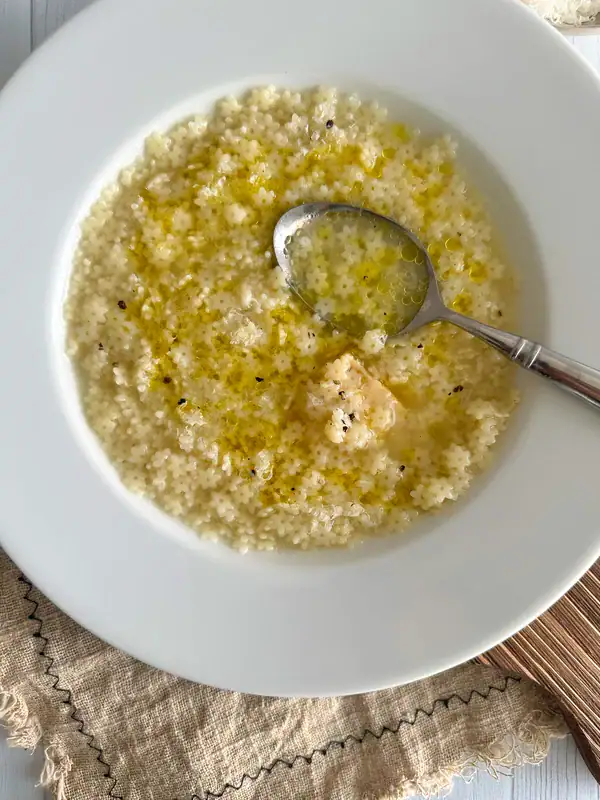 Close up of pastina in a plate with a eind of Parmesan Cheese