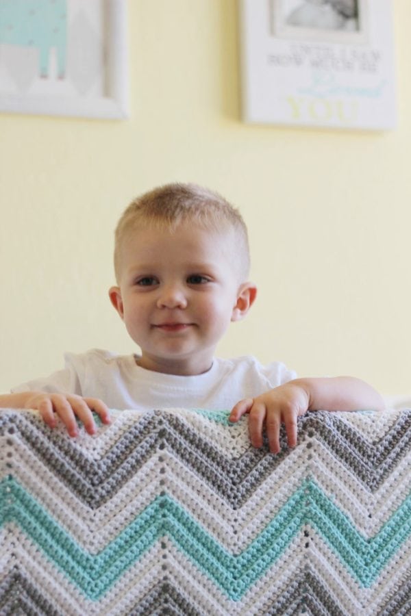 toddle in crib with chevron blanket