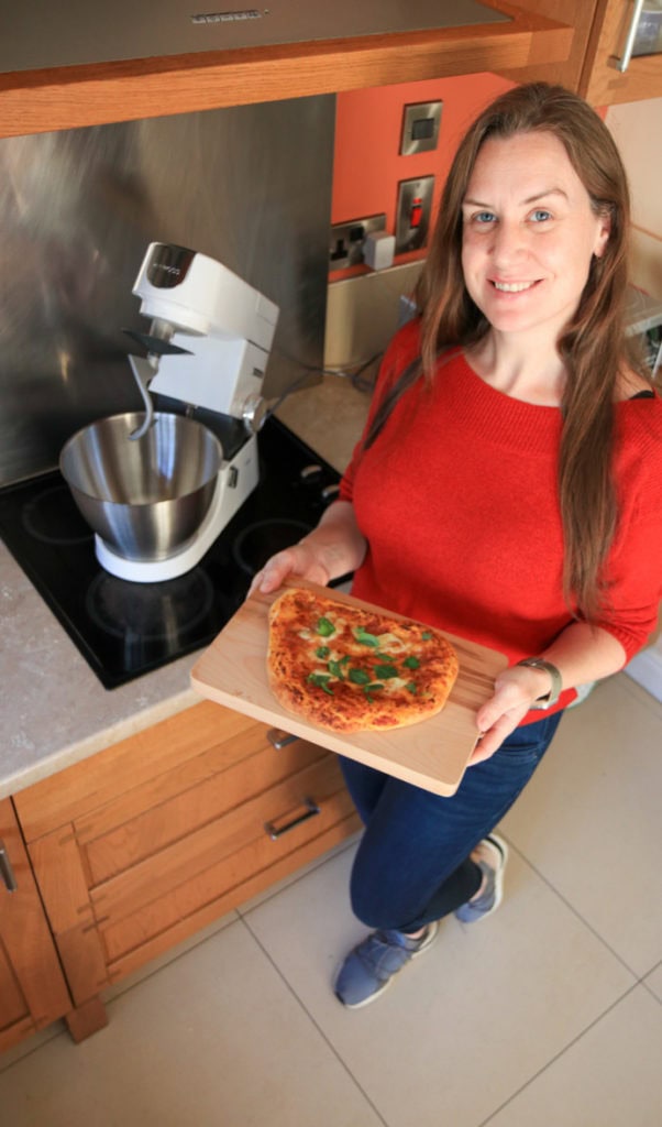 Melanie May Travel Journalist and Food Blogger holding the pizza she made