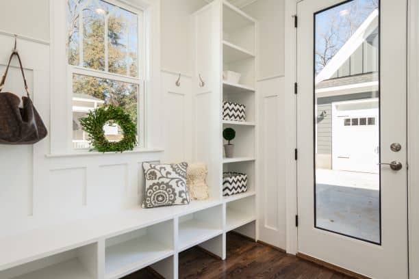 shoe bench under window near door with storage shelves,