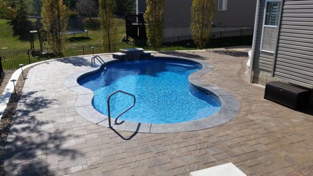 a traditional pool backyard with stamped cantilevered coping concrete around