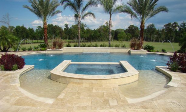 a grecian shaped pool with travertine stamped concrete decking around