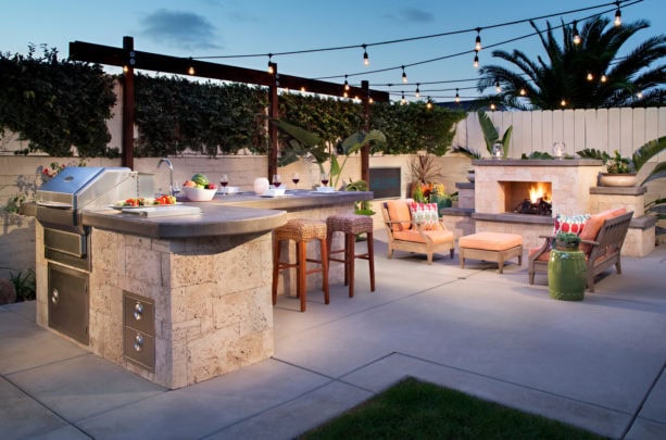 tropical l-shaped outdoor kitchen patio completed with a gas fireplace