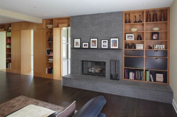 mid-century modern style fireplace with black strip tile around and dark mantel