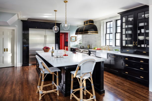 large country kitchen equipped with polished white cabinets and glossy black countertops