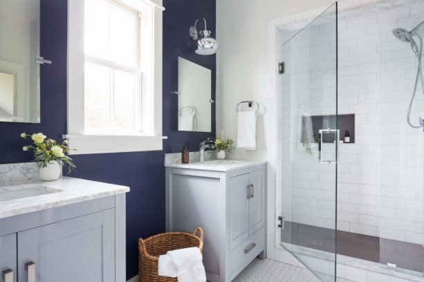 a farmhouse bathroom with clean white floor and navy blue walls for contrast