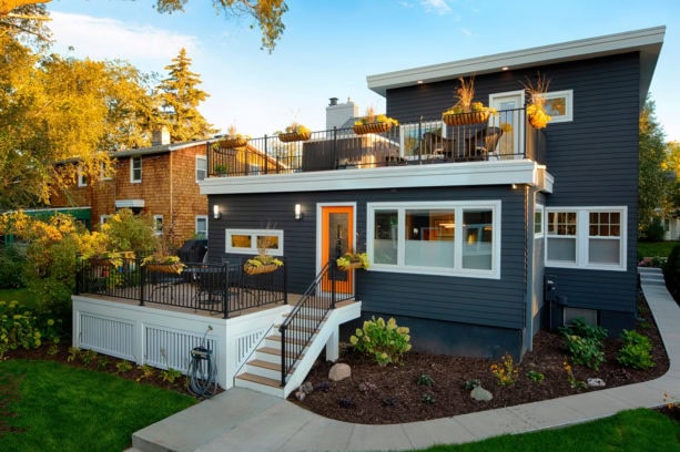 modern ranch style dark charcoal grey vinyl siding exterior house with a shingle roof