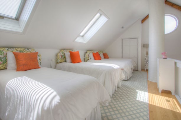 spacious guest’s bedroom in the attic with polished slanted walls