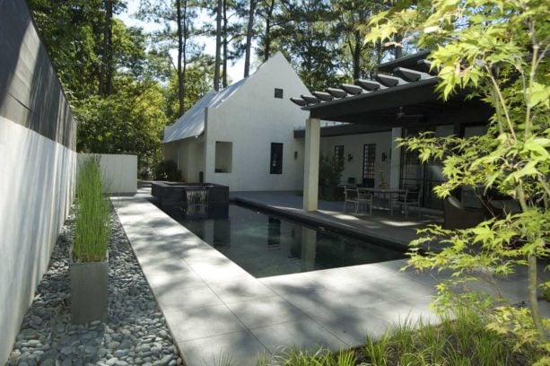 a minimalist backyard with stamped concrete around a rectangular pool