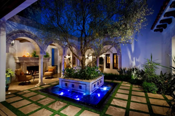 spanish mediterranean style home featuring a courtyard with stunning water feature