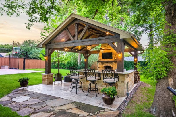 travertine tile covered patio with ledgestone wood burning fireplace