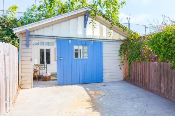 bold blue side sliding garage door combined with gray siding