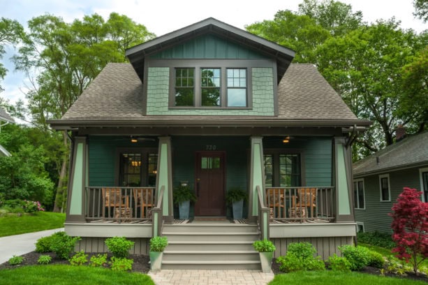 ranch style home with a mid-sized front porch in a green color