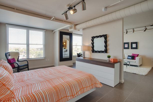 a buffet was placed against a small wall in the middle of the bedroom’s opening as a room divider