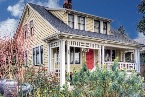 craftsman exterior with coral front door and yellow wood siding