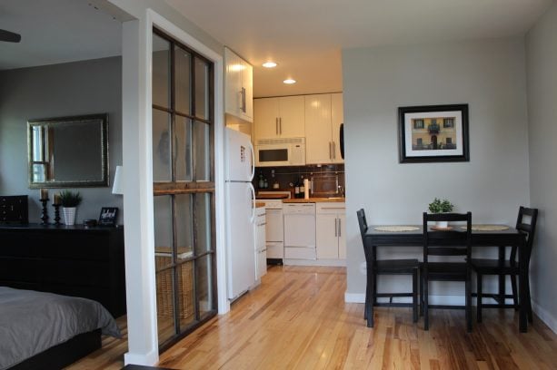 glass panels with white trim room divider in a modern studio apartment