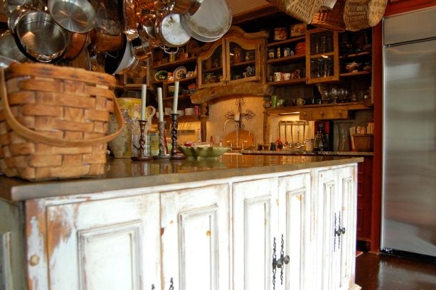 large cottage kitchen with white distressed kitchen island cabinet with brown glaze