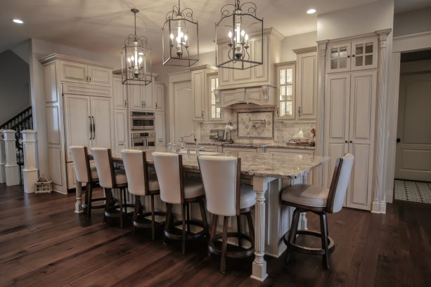 victorian style kitchen with an all-white design and distressed cabinet to create a classic look