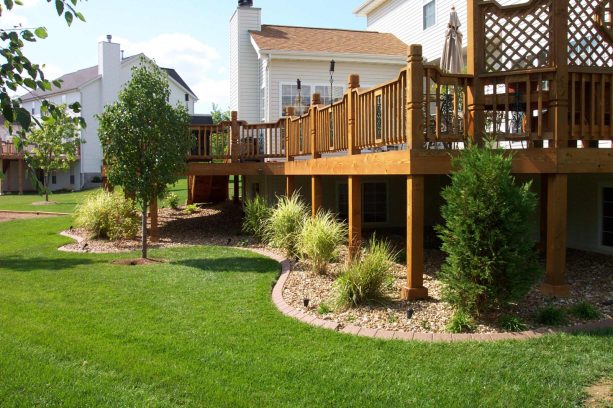 pea gravel with shrubs and small trees bordered by an edging in an under deck landscaping