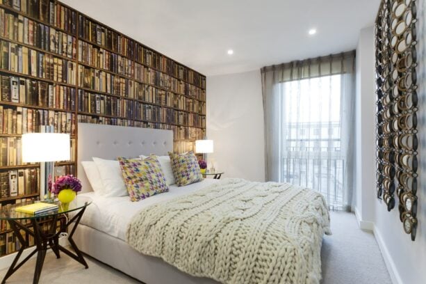 vintage bookshelf wallpaper accents in an eclectic bedroom