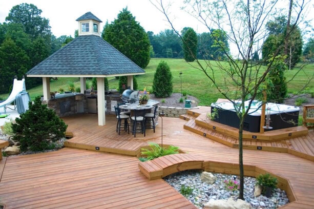 a gazebo without a railing is used as an outdoor kitchen on a deck