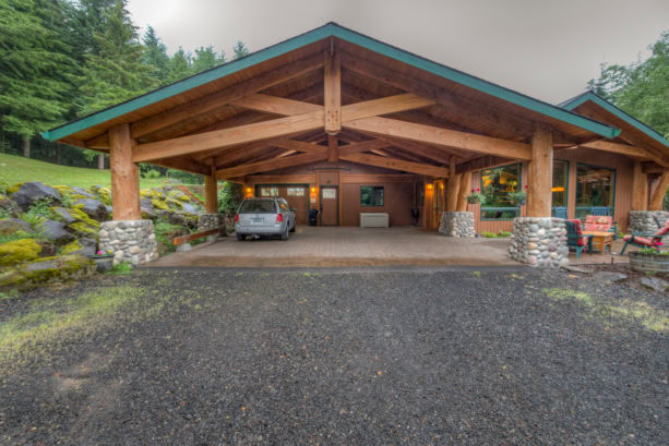 spacious mountain style post and beam carport with green trim