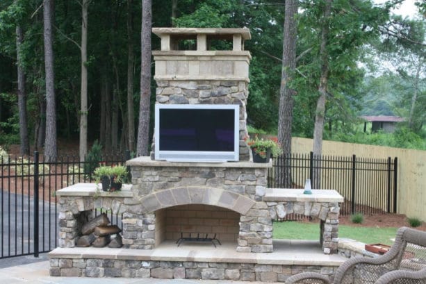 beautiful side yard with DIY outdoor fireplace kit and 36 inch tv