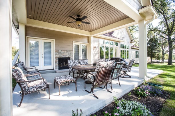 traditional poured concrete covered patio with double-sided fireplace