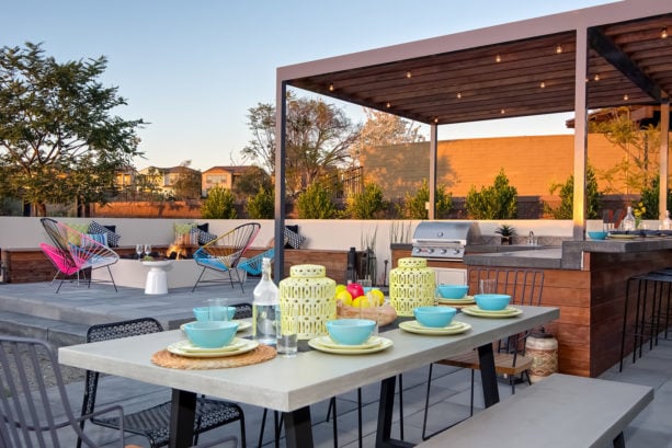 covered outdoor patio kitchen with l-shaped design and open concept dining area