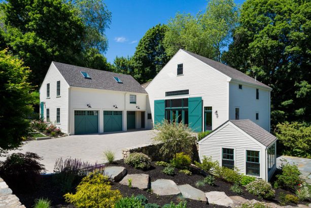 white cottage house with huge double sliding barn front doors in teal