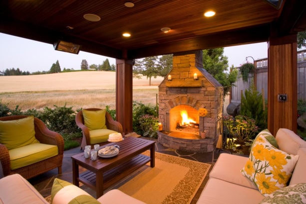 slate carpeted covered patio with fieldstone fireplace