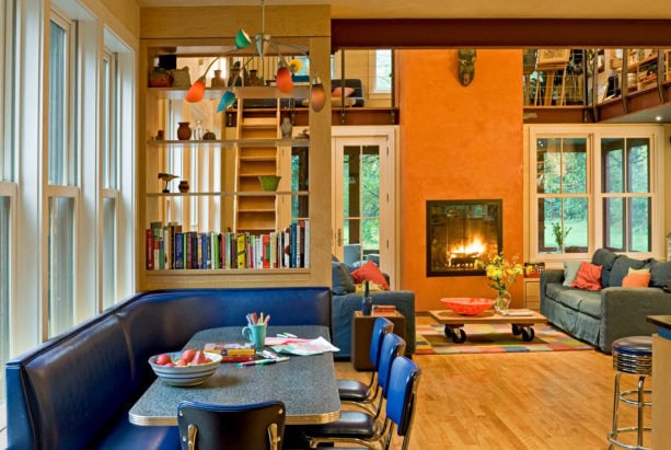 custom tinted orange plaster wall and retro cobalt blue diner booth in an open living room