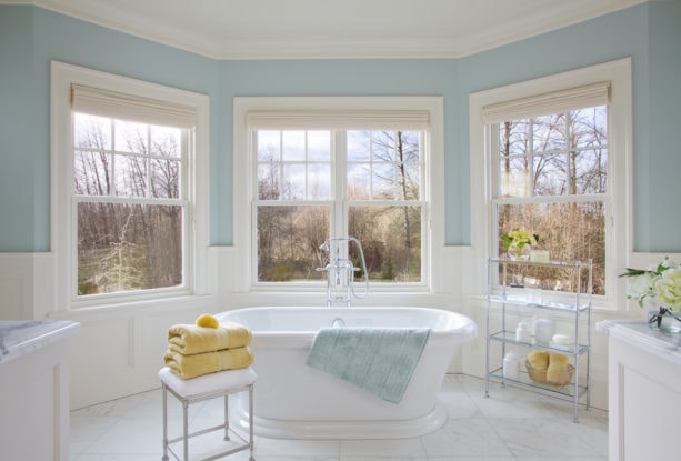 a traditional bathroom with soft blue walls and white tile porcelains to give a relaxing sensation