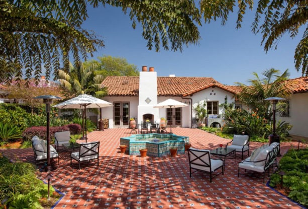 one-story spanish style home completed with a courtyard tile patio