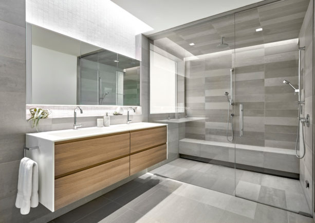 grey master bathroom without a tub completed with light-wood cabinets