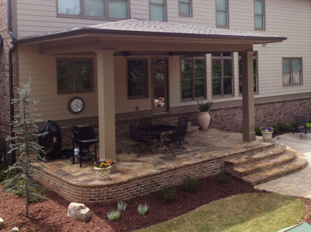 the small and open back porch is made of stone and brick