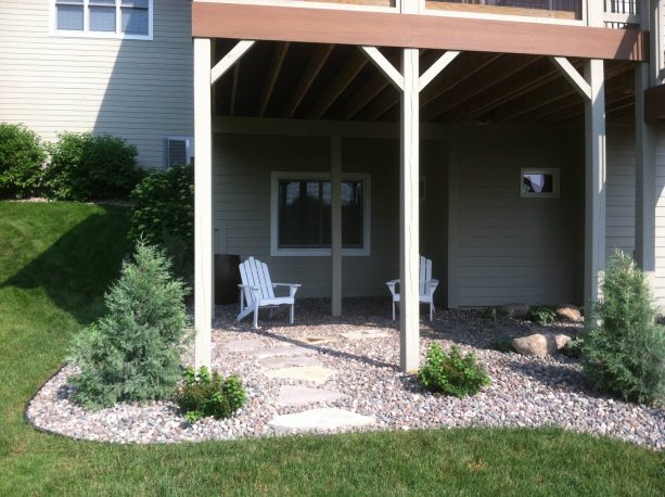 stone under deck landscaping with a seating space