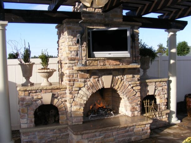 custom designed wood burning fireplace to accommodate an outdoor rated tv