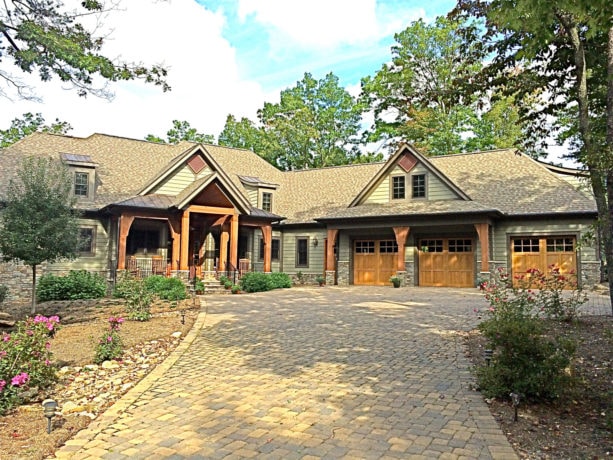 large mountain style green two-story house with brown trim