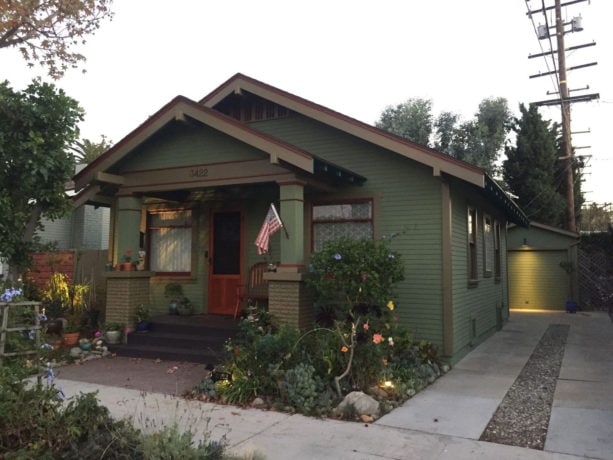 small arts and crafts green one-story stucco gable roof with brown trim