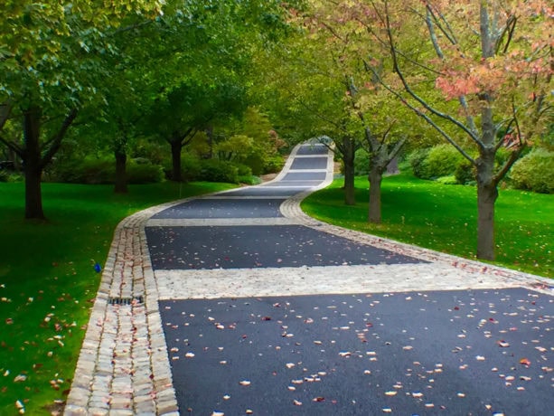 mix of belgian porphyry squares, reclaimed curbing, and european sandstone to widen a driveway