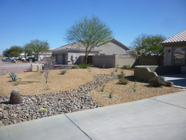 desert landscape with river rock garden, berming, and minimal desert planting